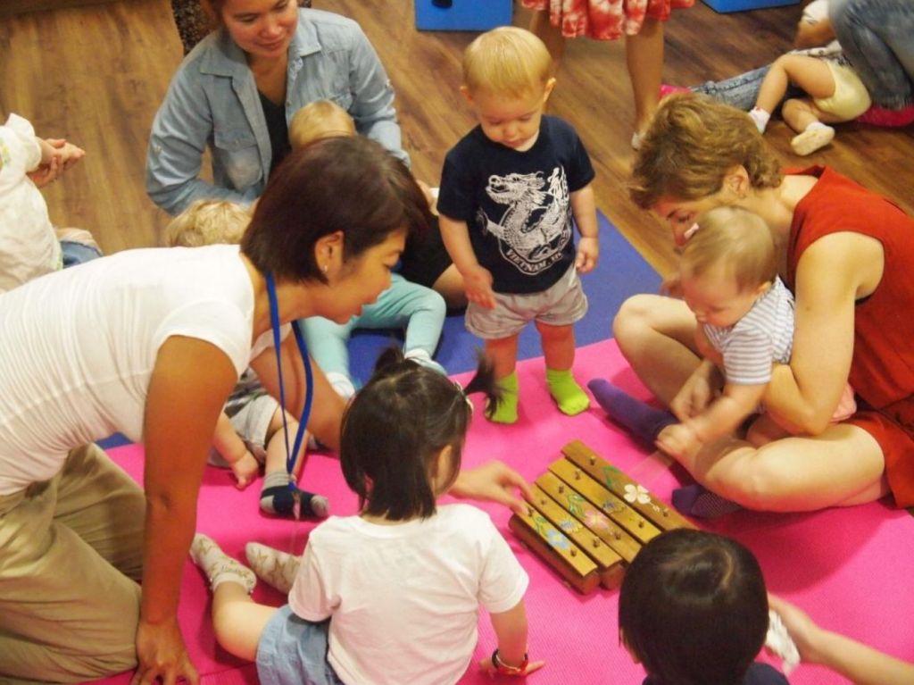 Babies and toddlers exploring Indonesian gamelan wooden xylophone in music playgroup