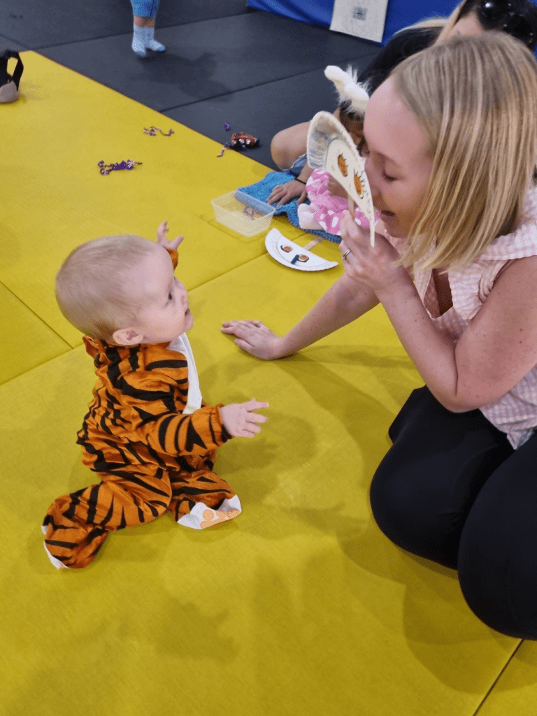 Mother and infant exploring a hands-on craft in baby toddler music playgroup