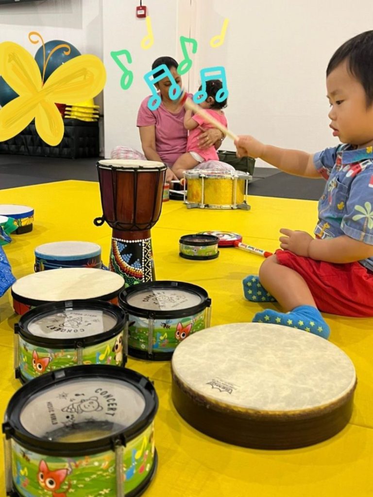 Kids enjoying drum play activity during baby and toddler music class