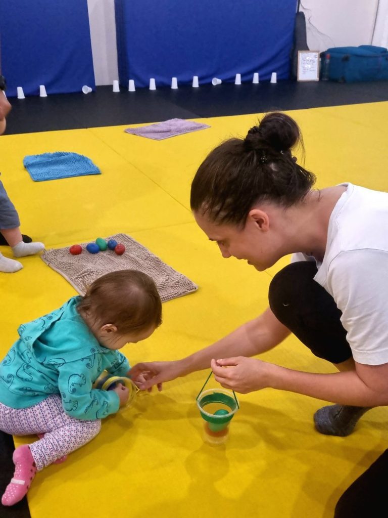 Mom and baby doing a simple craft activity together in a baby music playgroup