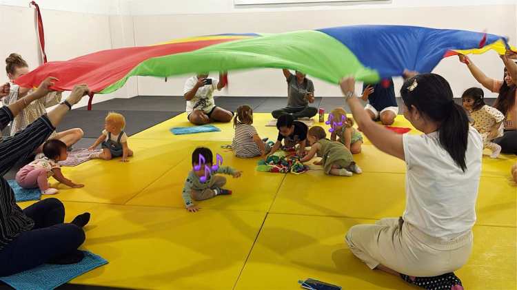 Babies and toddlers having fun during Parachute Play